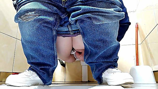 Hot MILF in jeans pissing in a public restroom